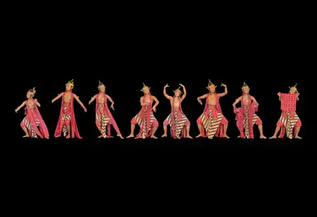 Eight traditional dancers in a horizontal procession against black