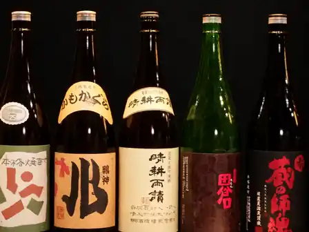 Five Japanese bottles with calligraphic labels against black, Kyoto, Japan